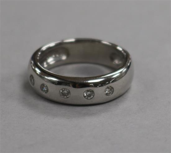 A modern 18ct white gold and five stone gypsy set diamond ring, size K.